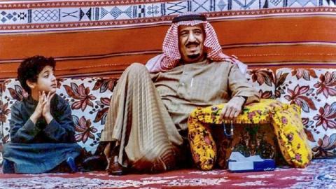 من الصبي الجالس إلى جانب الملك سلمان بن عبد العزيز؟ (صور)